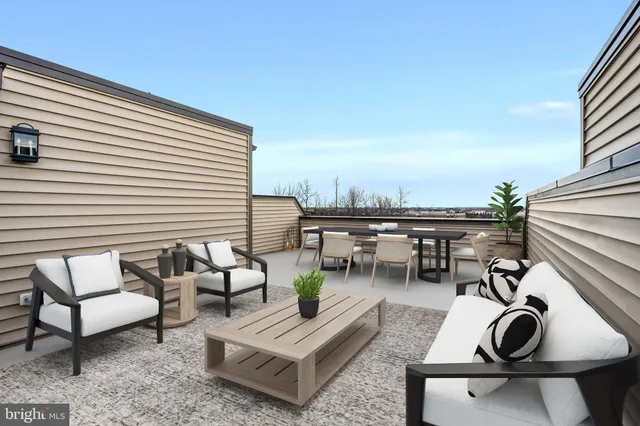 a roof deck with a couch and chairs