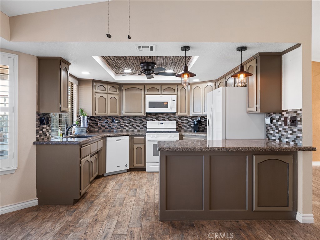 16986 Ocotilla Road Apple Valley, CA 92307 - Photo 11 of 39 a kitchen with stainless steel appliances kitchen island granite countertop a sink and cabinets