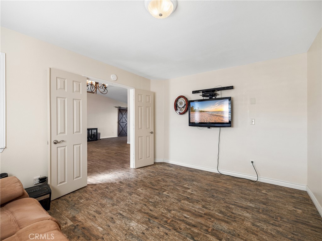 16986 Ocotilla Road Apple Valley, CA 92307 - Photo 16 of 39 a view of a livingroom with wooden floor and a flat screen tv