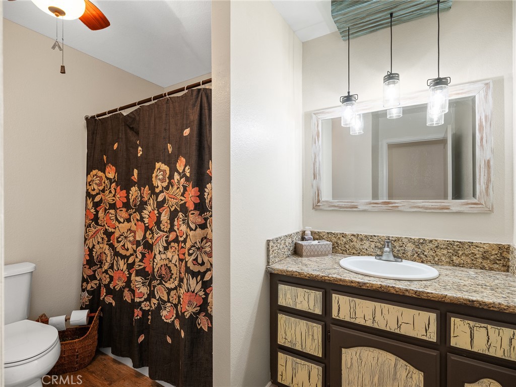 16986 Ocotilla Road Apple Valley, CA 92307 - Photo 18 of 39 a bathroom with a granite countertop sink a toilet and shower