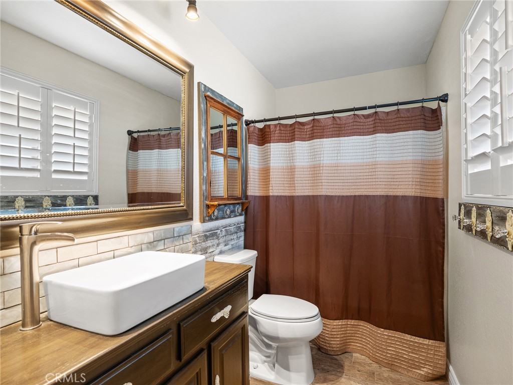 16986 Ocotilla Road Apple Valley, CA 92307 - Photo 25 of 39 a bathroom with a sink a toilet a mirror and shower