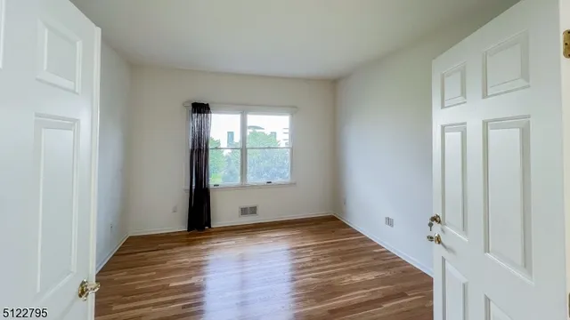 a view of a room with wooden floor and window