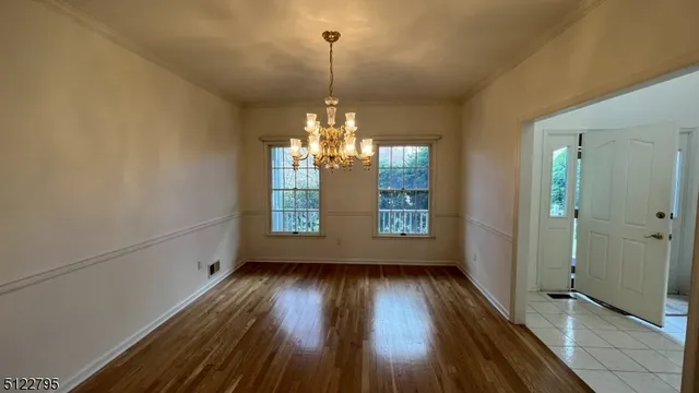 a view of a room with wooden floor and entryway