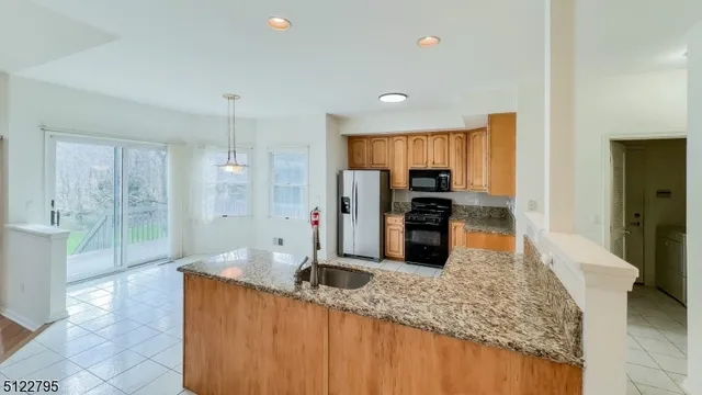 a kitchen with stainless steel appliances granite countertop a sink refrigerator and cabinets