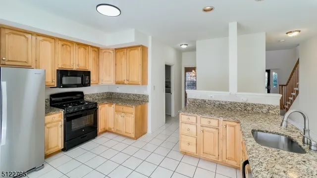 a kitchen with granite countertop a stove sink and refrigerator
