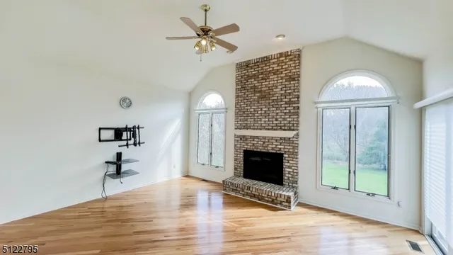 a view of an empty room with a fireplace and a window