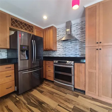 a kitchen with stainless steel appliances granite countertop a refrigerator and a sink
