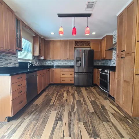 a kitchen with stainless steel appliances granite countertop a stove refrigerator and cabinets