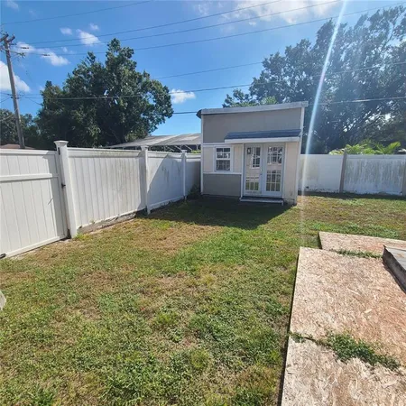 a view of a house with a small yard and wooden fence