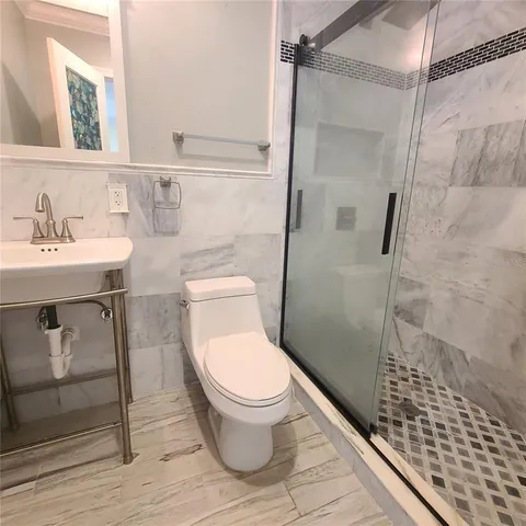a white toilet sitting next to a bathroom sink