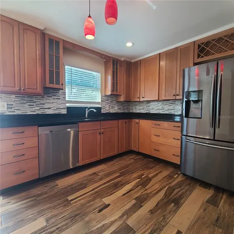 a kitchen with granite countertop a sink stainless steel appliances and cabinets