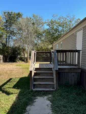 a view of a backyard with wooden fence and large trees