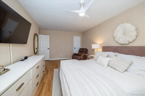 a bedroom with a bed and a flat tv screen on dresser