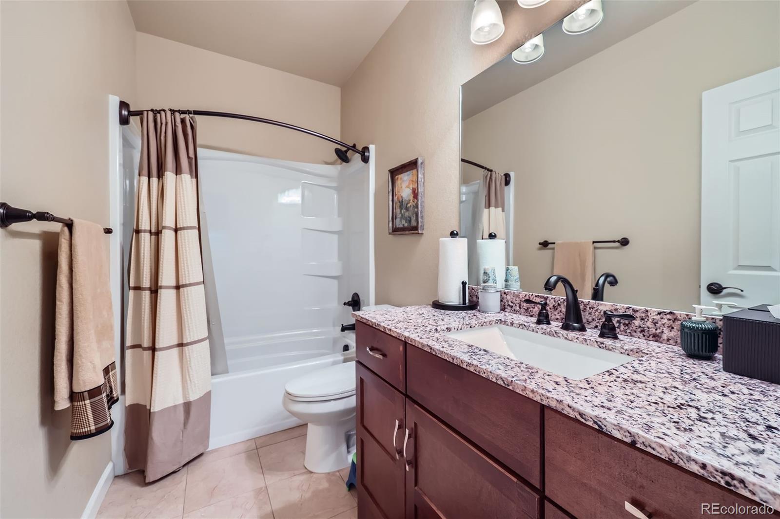 2872 Dreamcatcher Loop Castle Rock, CO 80109 - Photo 29 of 42 a bathroom with a granite countertop sink a toilet and a large mirror