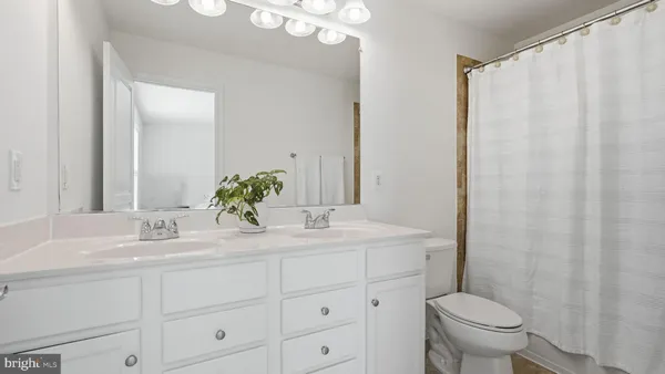 a bathroom with a granite countertop sink a toilet and a mirror