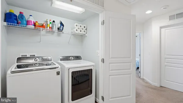 a utility room with dryer washer and empty racks