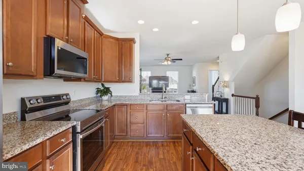a kitchen with stainless steel appliances granite countertop a sink stove microwave and cabinets