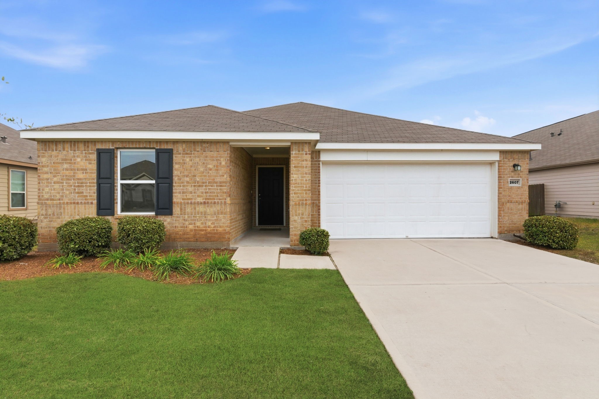 a front view of a house with a yard and garage