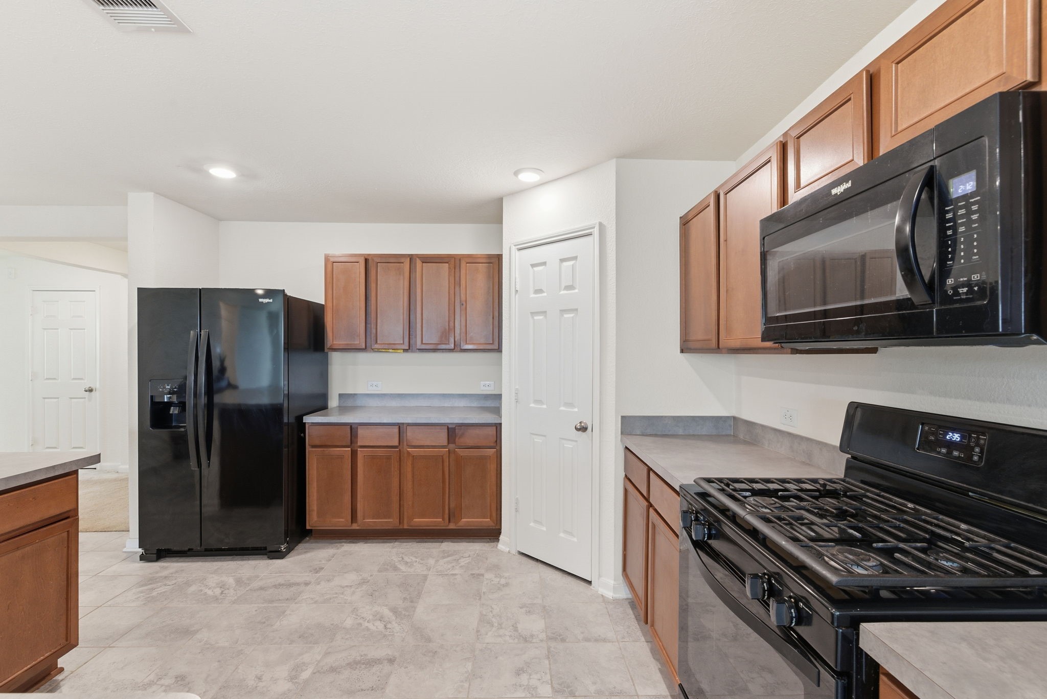 2607 Little Bluestem Lane Rosenberg, TX 77469 - Photo 6 of 20 a kitchen with granite countertop stainless steel appliances a refrigerator a stove top oven and granite top