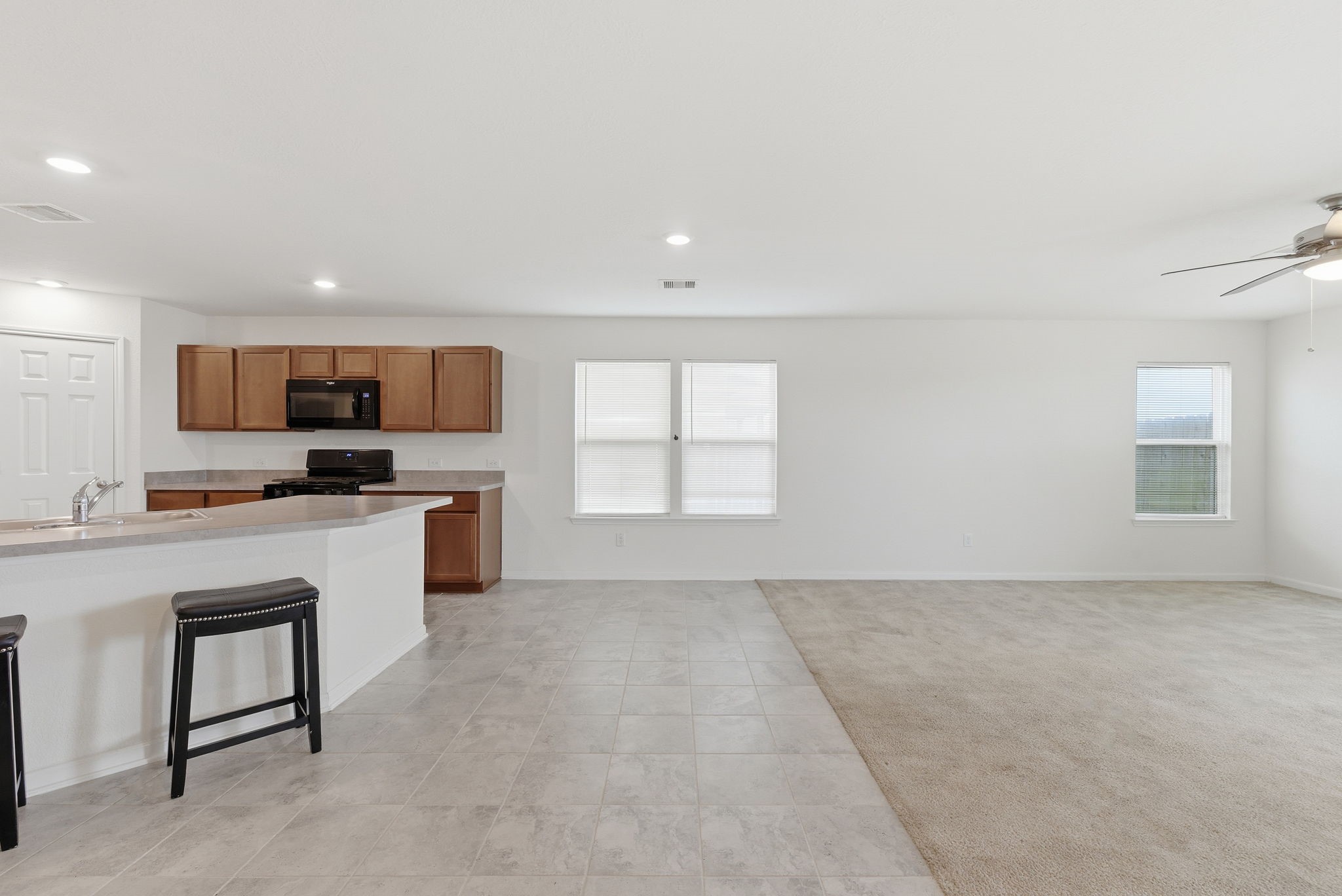 2607 Little Bluestem Lane Rosenberg, TX 77469 - Photo 7 of 20 a open kitchen with kitchen island a sink white cabinets and stainless steel appliances