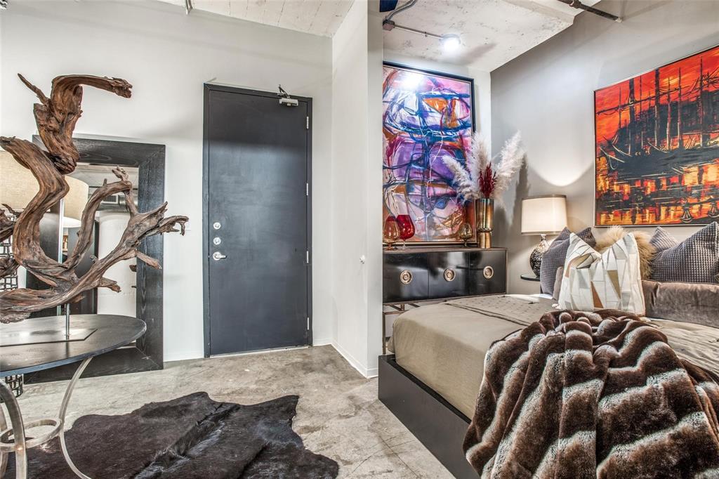 1122 Jackson Street, Unit 322 Dallas, TX 75202 - Photo 17 of 25 a bedroom with a bed and dresser with mirror