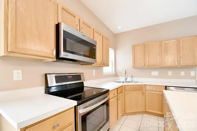 a kitchen with stainless steel appliances a stove microwave and sink
