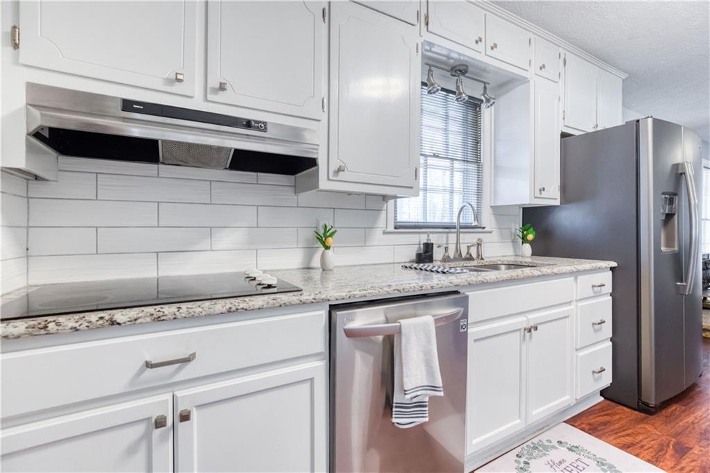 23 Woodland Road Auburn, GA 30011 - Photo 13 of 34 a kitchen with stainless steel appliances granite countertop a sink stove and refrigerator