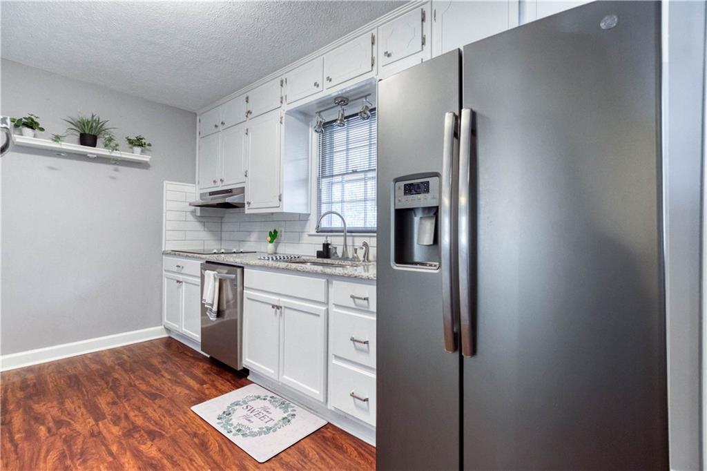 23 Woodland Road Auburn, GA 30011 - Photo 15 of 34 a kitchen with stainless steel appliances granite countertop a refrigerator sink and stove