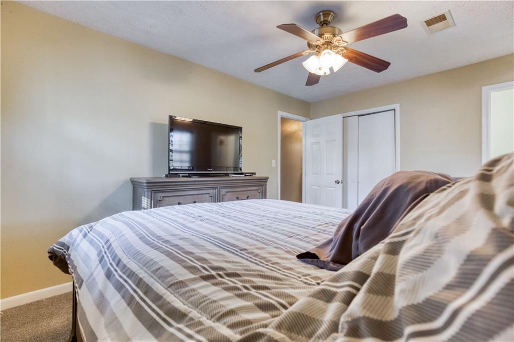 23 Woodland Road Auburn, GA 30011 - Photo 19 of 34 a bedroom with a bed and a flat screen tv