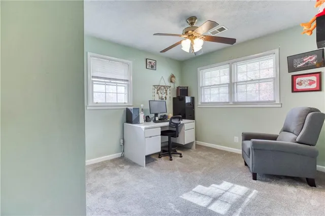 a view of a livingroom with workspace and a window