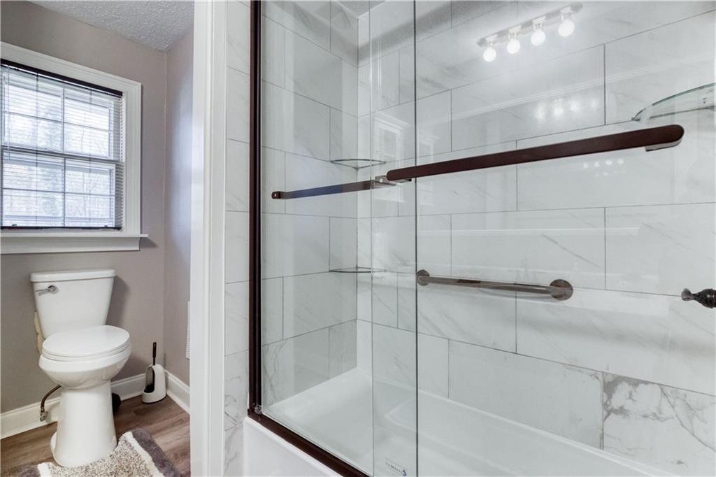 23 Woodland Road Auburn, GA 30011 - Photo 24 of 34 a bathroom with a toilet and a shower
