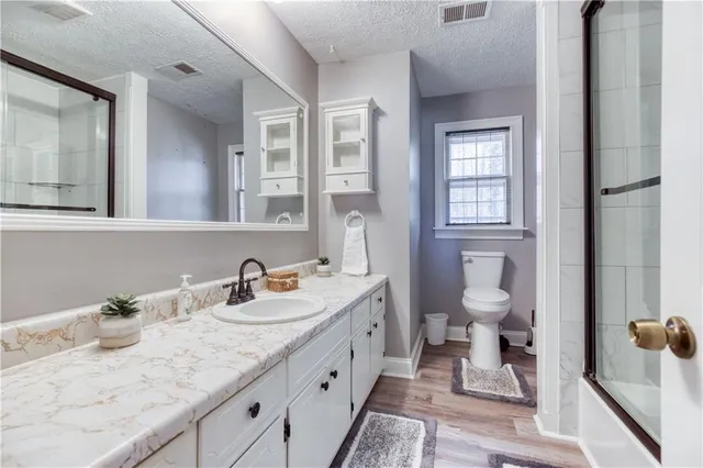 a bathroom with a granite countertop sink mirror and toilet