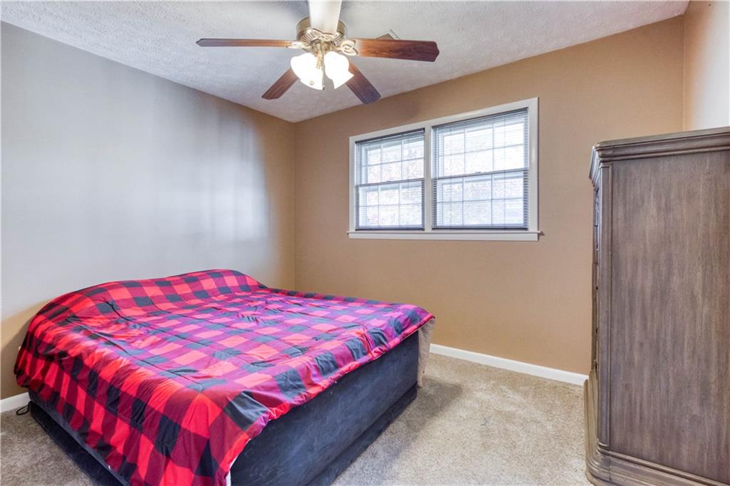 23 Woodland Road Auburn, GA 30011 - Photo 26 of 34 a bedroom with a bed and a chandelier