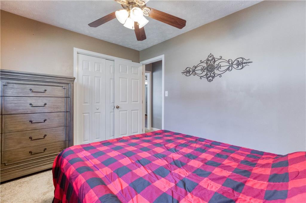 23 Woodland Road Auburn, GA 30011 - Photo 27 of 34 a bedroom with a large bed and a chandelier