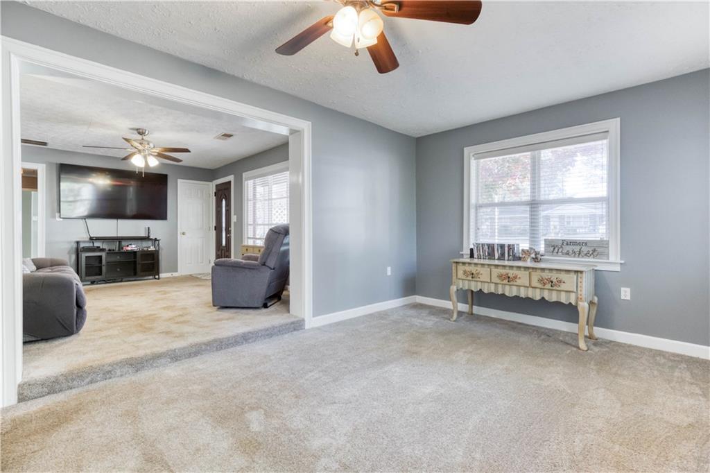 23 Woodland Road Auburn, GA 30011 - Photo 5 of 34 a living room with furniture a flat screen tv and a large window