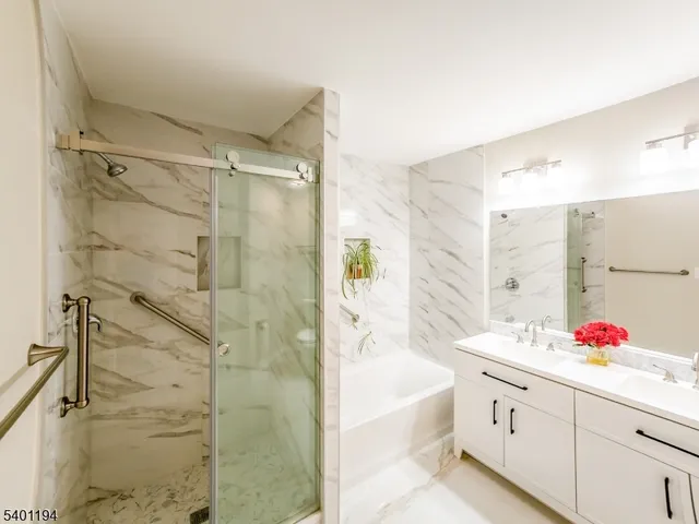 a bathroom with a tub sink mirror and shower