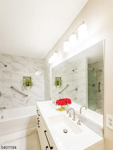 a bathroom with a sink vanity tub and shower