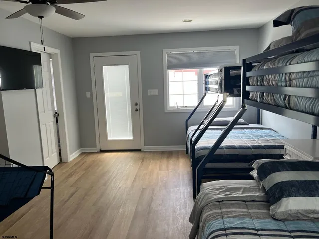 a view of a livingroom with furniture a fireplace wooden floor and windows