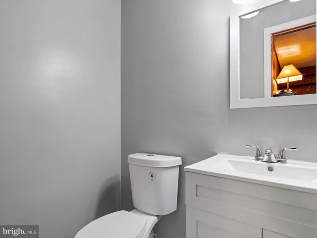 a bathroom with a toilet a sink and mirror