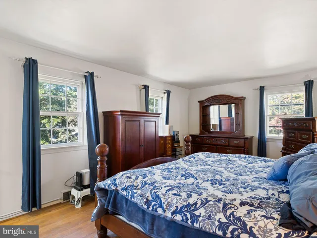 a bedroom with a bed dresser and a window