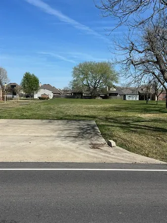 a view of a field with a house in the background