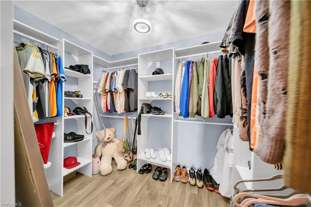 175 Shadowview Court Lehigh Acres, FL 33974 - Photo 25 of 39 a view of walk in closet with clothes and shoes