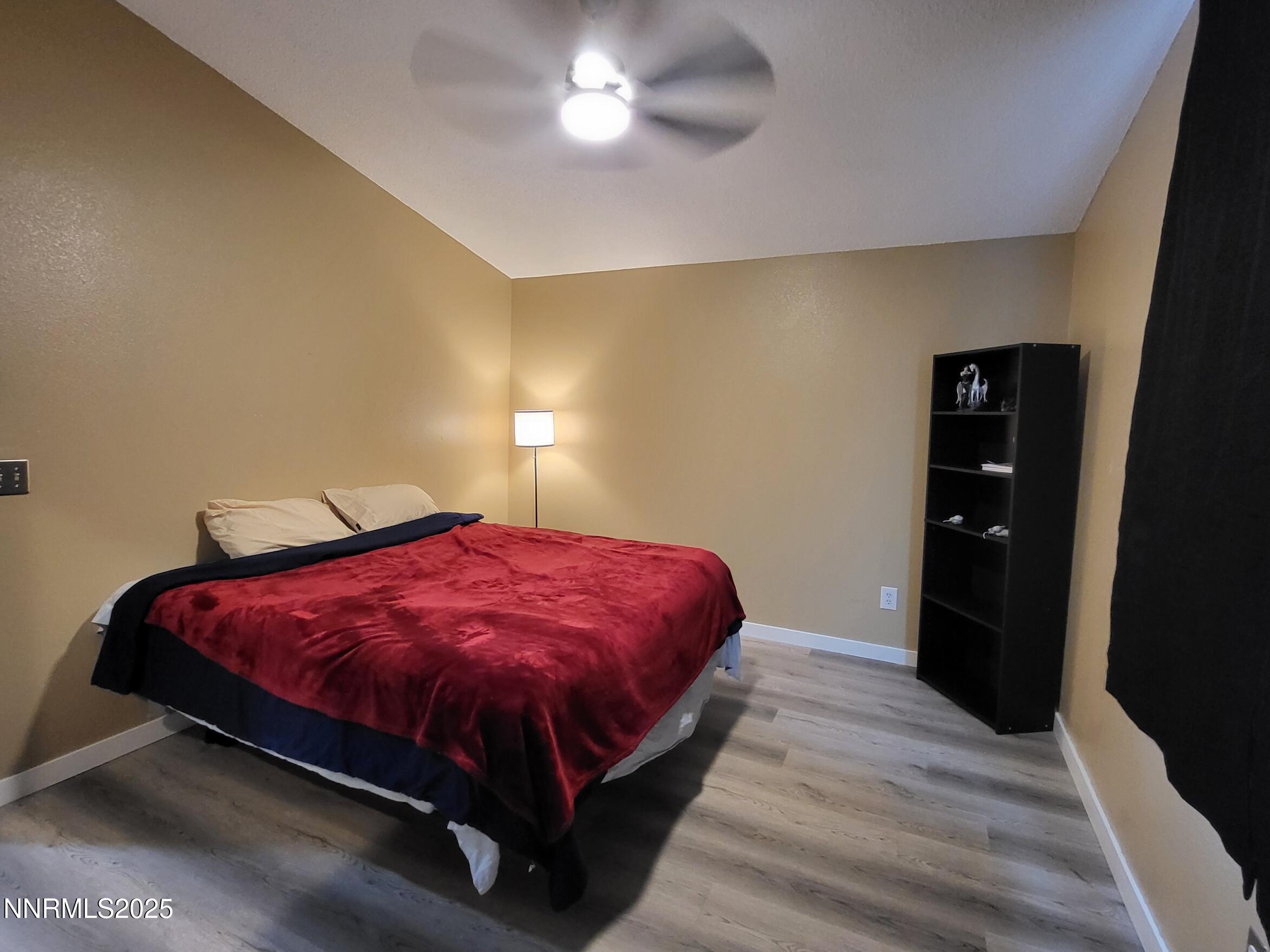 7871 Anchor Point Court Reno, NV 89506 - Photo 16 of 42 a spacious bedroom with a bed and a chandelier