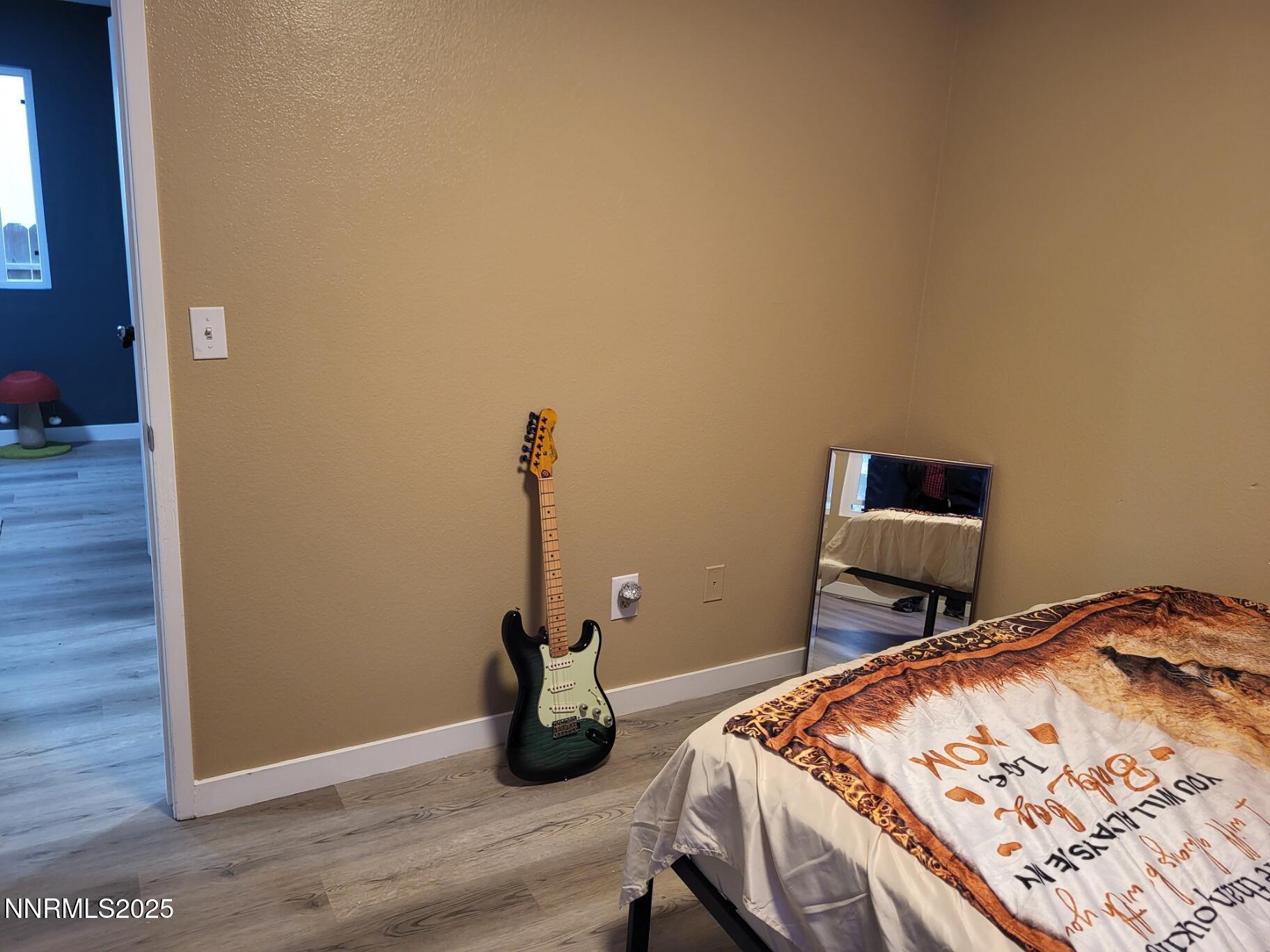 7871 Anchor Point Court Reno, NV 89506 - Photo 26 of 42 a bedroom with a bed and a wooden floor
