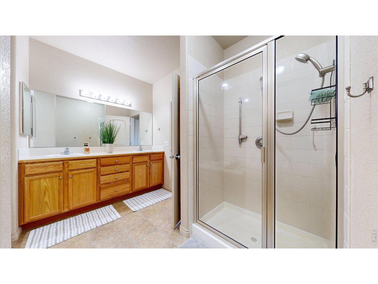 4672 West 20th Road, Unit 413 Greeley, CO 80634 - Photo 21 of 37 a bathroom with a double vanity sink mirror and shower