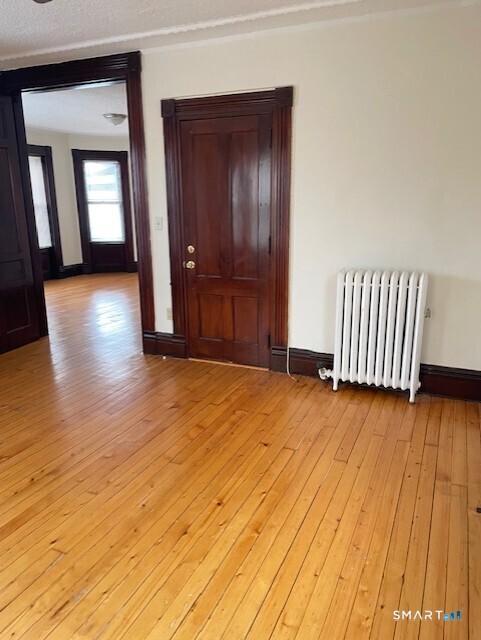281 Chestnut Street New Britain, CT 06051 - Photo 15 of 18 an empty room with wooden floor and windows