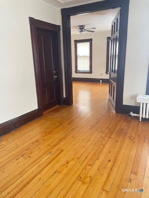 281 Chestnut Street New Britain, CT 06051 - Photo 16 of 33 a view of empty room with wooden floor and fan