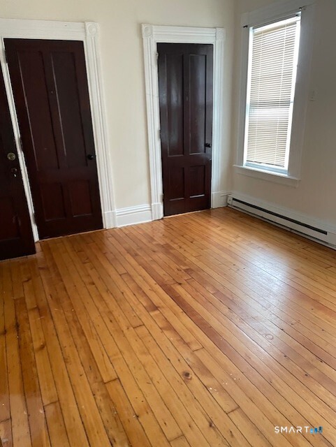 281 Chestnut Street New Britain, CT 06051 - Photo 17 of 18 a bedroom with a bed and wooden floor