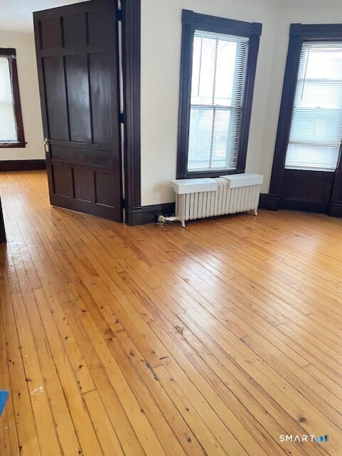 281 Chestnut Street New Britain, CT 06051 - Photo 21 of 33 an empty room with wooden floor and windows
