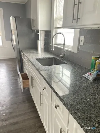 a kitchen with granite countertop a sink and a stove